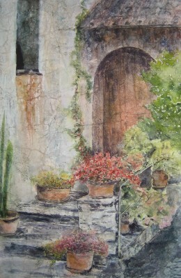 Potted plants on the steps of a home leading to a wooden door